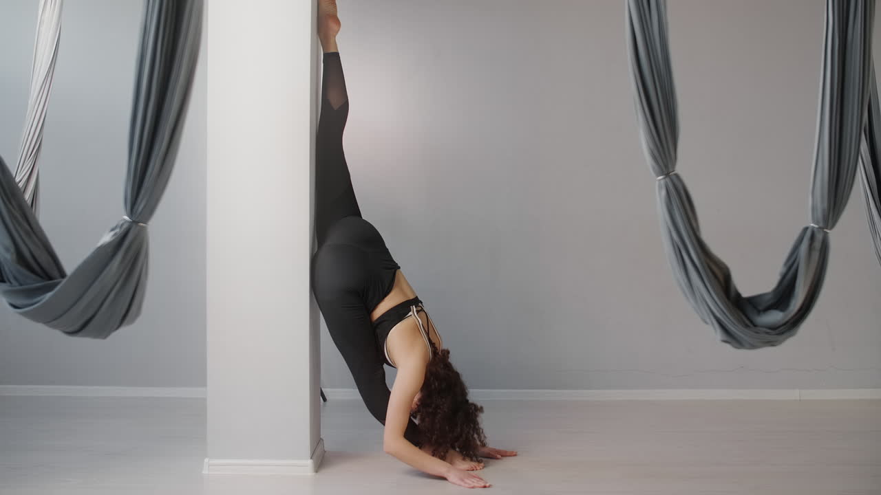 Woman Performing Yoga Stretches and Aerial Yoga Poses