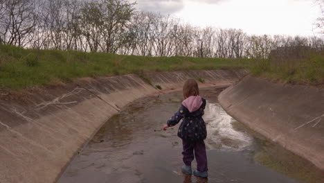 Siguiendo-A-Una-Niña-Caminando-Por-Un-Canal-De-Desvío