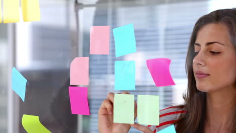 mujer escribiendo en una nota adhesiva