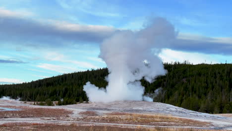 cinematic old faithful geyser sunrise sunset eruption explosion steam yellowstone national park observation deck upper geyser basin fall autumn beautiful blue sky slow motion pan follow up