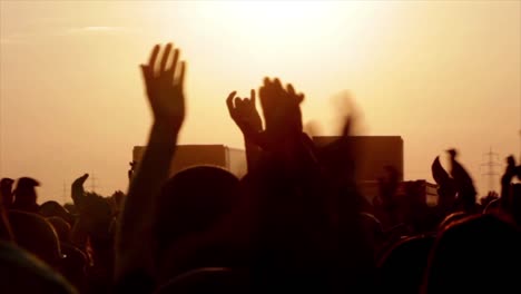 unrecognizable people holding hands up during concert