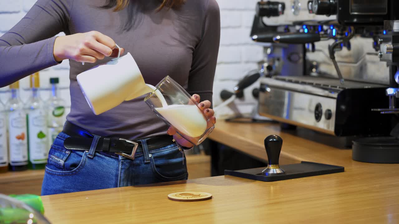 Barista working in coffee shop. Female barista making cup of coffee while standing behind cafe counter