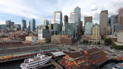 Mesmerizing drone flight over Seattle&#039;s bustling waterfront district, showcasing the vibrant blend of business activity, waterfront piers, towering skyscrapers, and architectural marvels