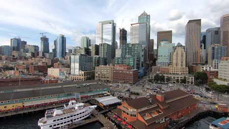 mesmerizing drone flight over seattle's bustling waterfront district, showcasing the vibrant blend of business activity, waterfront piers, towering skyscrapers, and architectural marvels