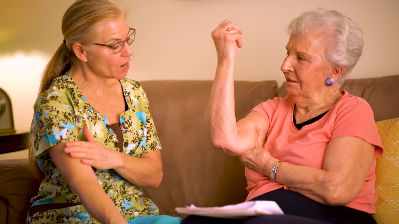 Closeup of home healthcare nurse helping elderly woman with arm range of motion stretches