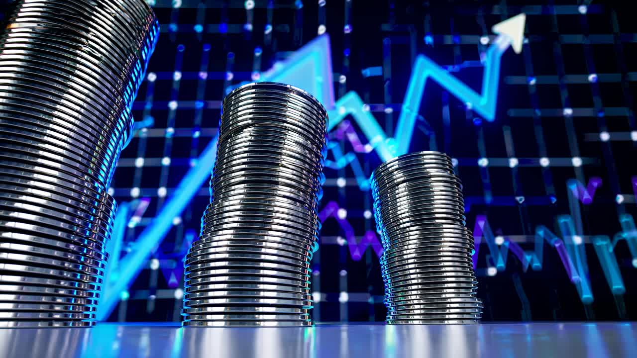 Low-angle video shot of stacked coins with a digital graph backdrop, symbolizing financial growth