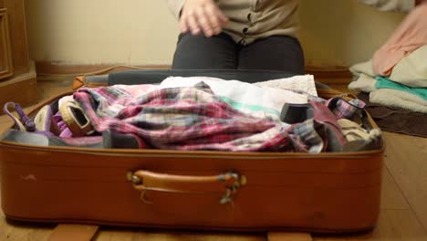 packing old brown suitcase with clothes medium shot timelapse