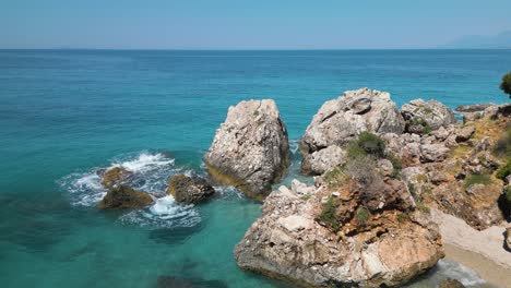 dolly above small boat anchored in rocky cove of tropical beach