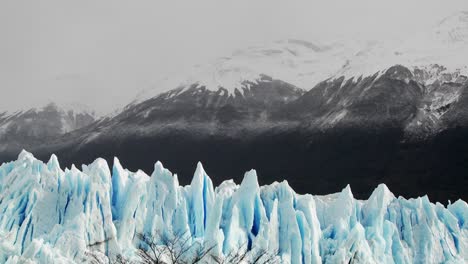 The-spiked-tops-of-a-glacier-stand-against-rugged-mountains-2