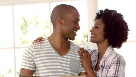 happy couple with moving box hugging