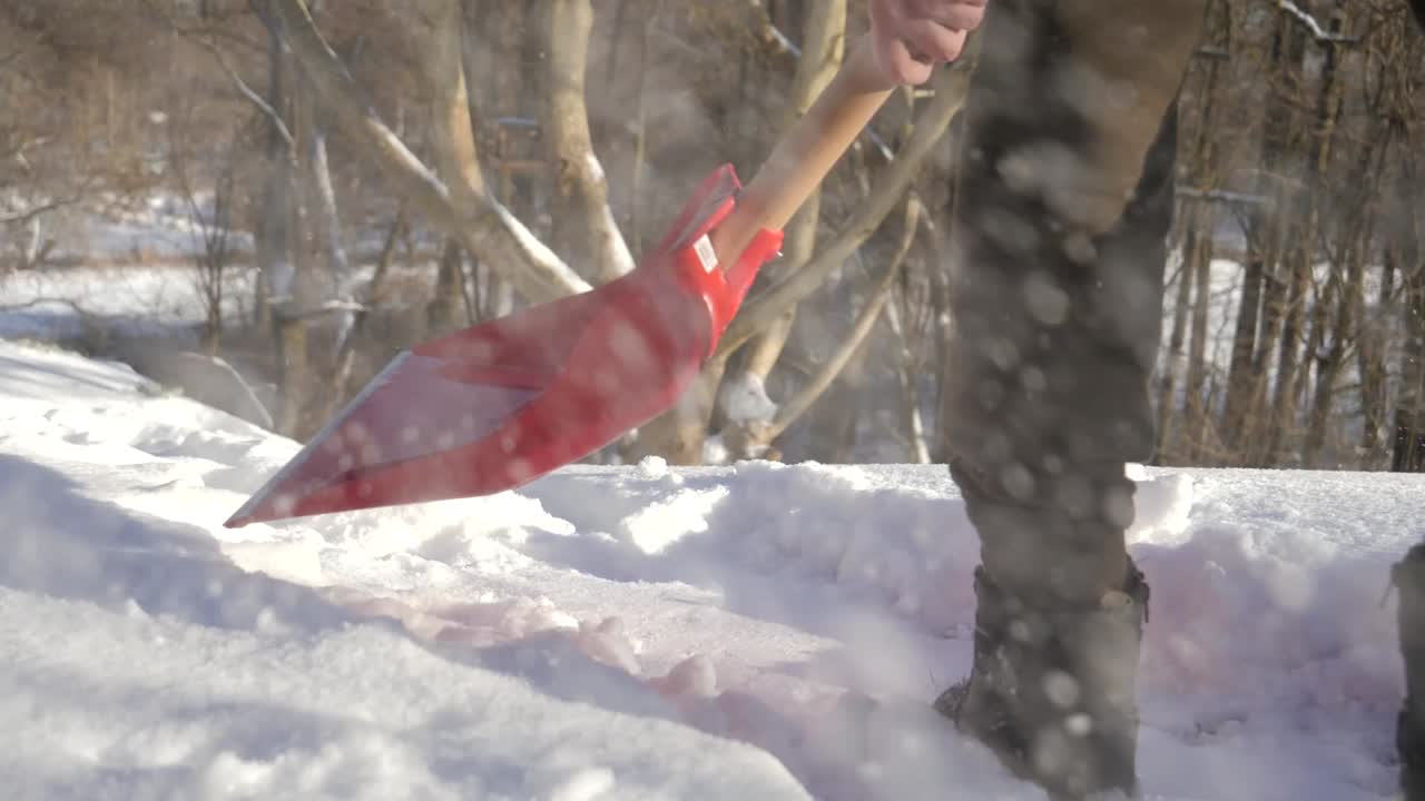 Shoveling snow on sunny winter hill