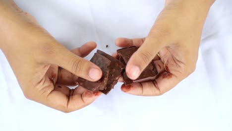 person breaking a chocolate bar