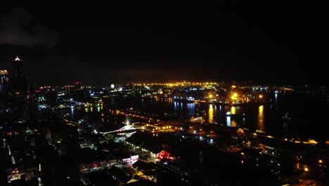 Funkelnde-Lichter-Der-Stadt-Am-Fluss-In-Der-Nacht,-Lebendige-Urbane-Szene