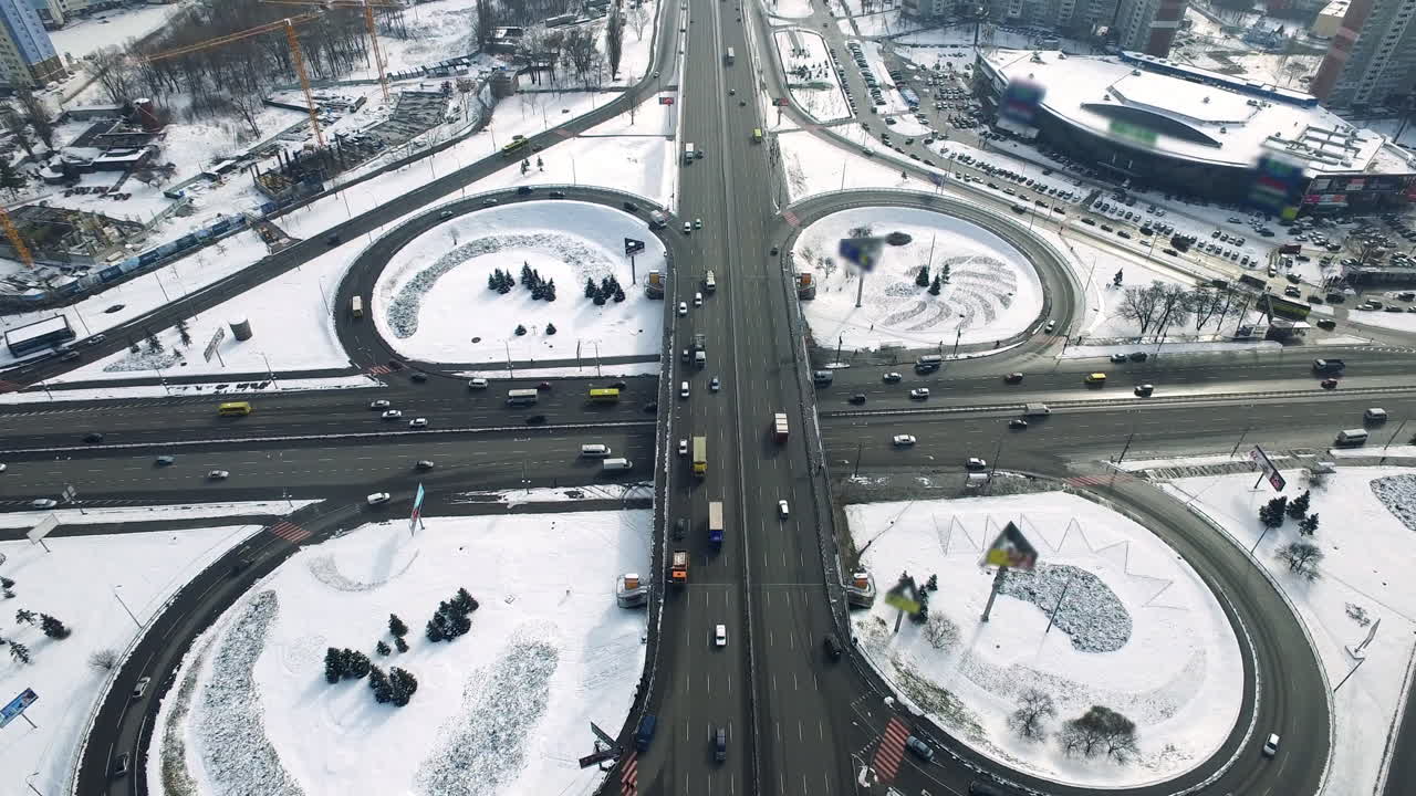 Auto in transito su autostrada sopraelevata in città d'inverno. Vista aerea di un cavalcavia autostradale in città.