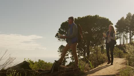 pareja de ancianos activos buscando el mapa en el bosque