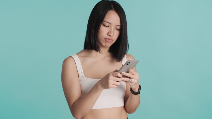 Asian woman texting on smartphone.