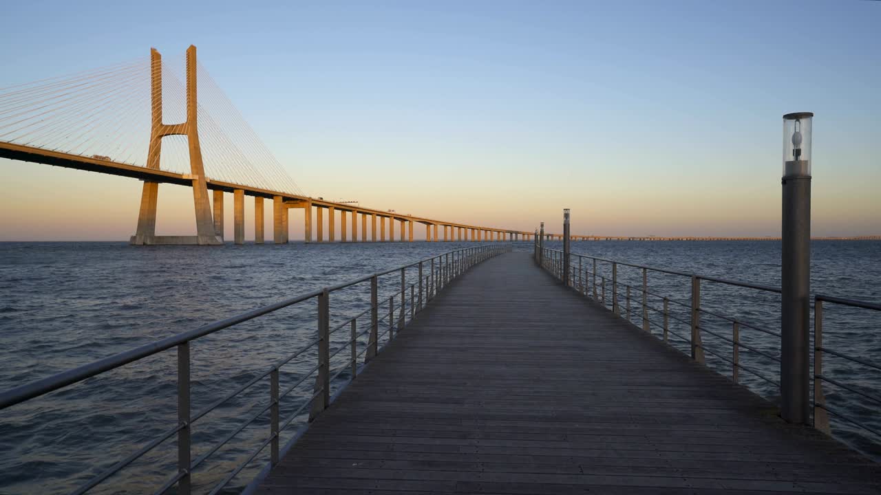 puente vasco da gama vista desde un muelle al atardecer