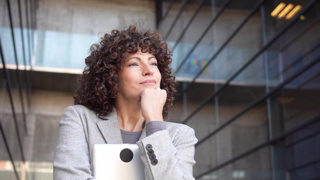 Una professionista utilizza efficacemente un tablet in un elegante ambiente d'ufficio moderno.