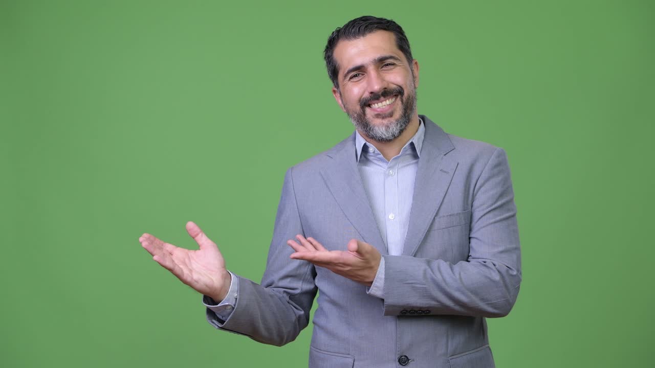 Handsome Persian bearded businessman showing something