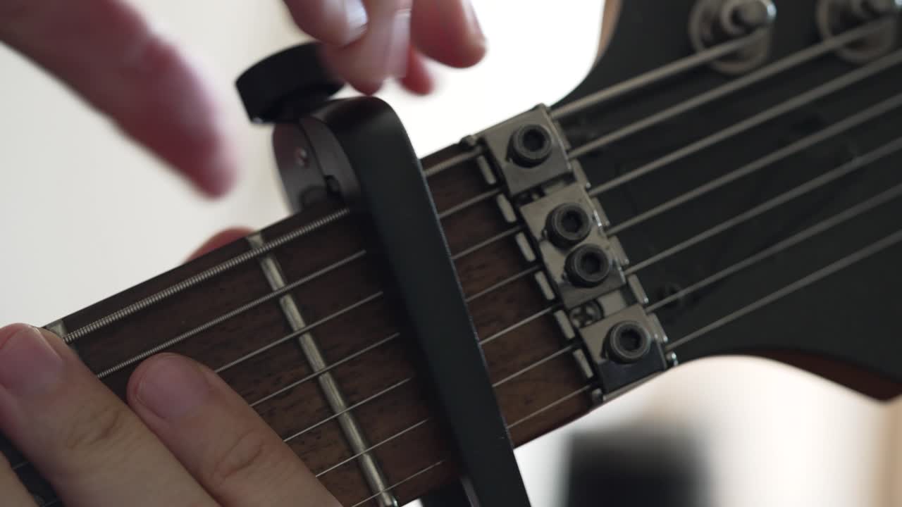 Capotasto rimosso dal manico di una chitarra elettrica a sette corde.