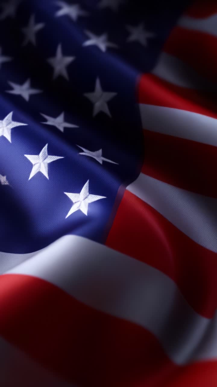 Primo piano di un tessuto con bandiera americana al vento che mostra stelle e strisce con splendide trame nei colori accesi rosso, bianco e blu, evidenziando l'orgoglio e il simbolismo nazionale