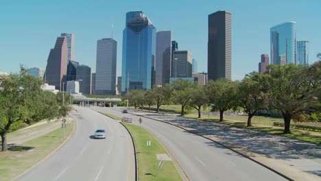 cars drive along a highway leading into downtown houston 2