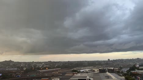 dramatic time-lapse shot capturing dark and dense rainstorm clouds accumulating and forming in the sky and sudden flash heavy rain across brisbane city, queensland, australia