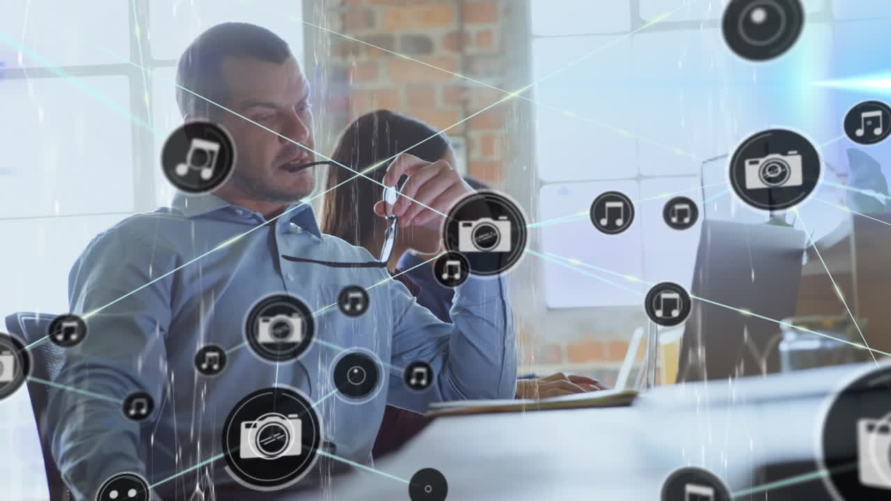 Animation of network of connections with icons over diverse business people working at office