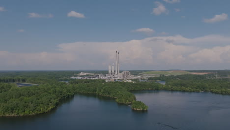 Rotación-Aérea-Y-Zoom-Lento-En-Una-Planta-De-Energía-En-Nubes-Brumosas-Por-La-Tarde-En-Un-Lago