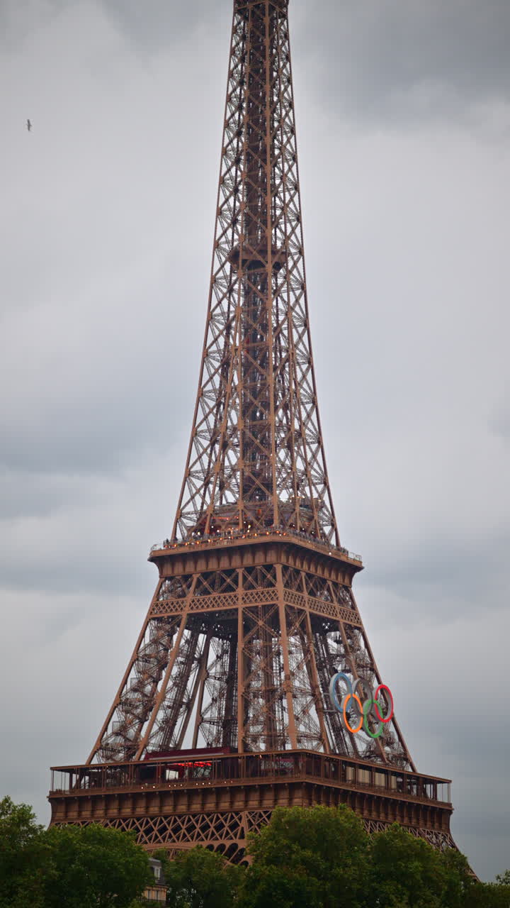 The Eiffel Tower with the Olympic Games sign in Paris, France. Verticalpst