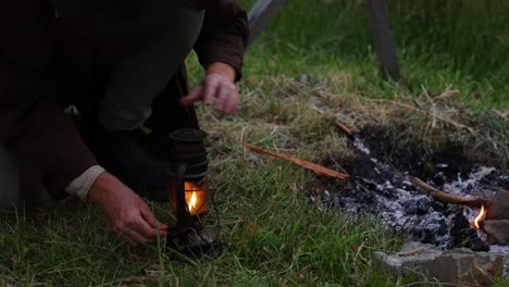 el bosquero australiano enciende una vieja linterna de queroseno con fuego en el bosque