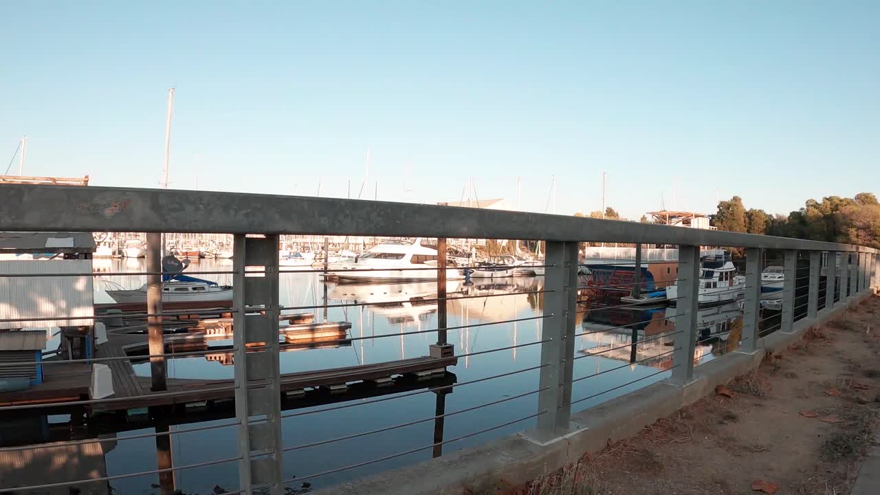 A view of the boats in the marina behind the retaining fence.