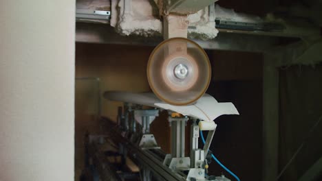 surfboard is crafted by power planer in slow motion while dust moves around