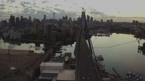 drone aerial view of traffic flowing over a suspended bridge across a river