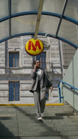 businesswoman walking up stairs at a metro station