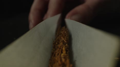 a close-up image capturing the process of rolling a cigarette by hand