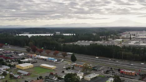 Vista-Del-Tráfico-Diurno-En-La-Autopista-En-El-Barrio-De-Tillicum-En-Lakewood,-Washington-Con-El-Monte-Más-Lluvioso-En-Un-Fondo-Distante