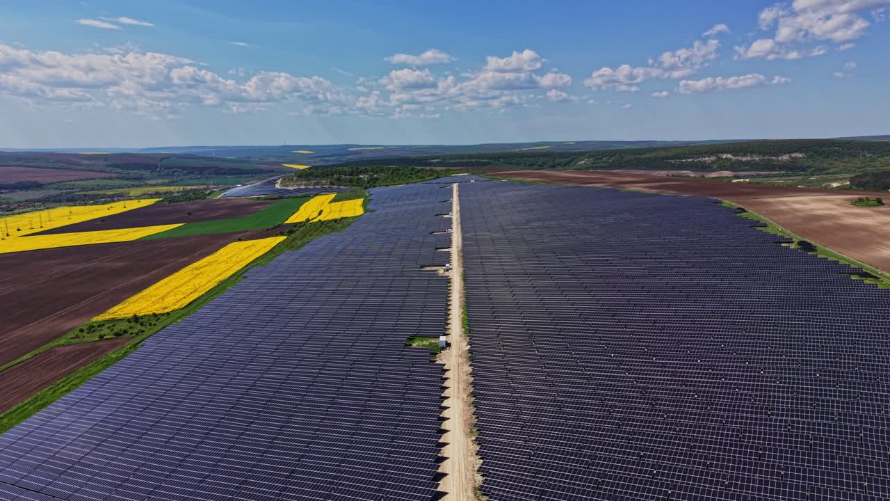 Stor solcellepark i et landområde med overskyet himmel.
