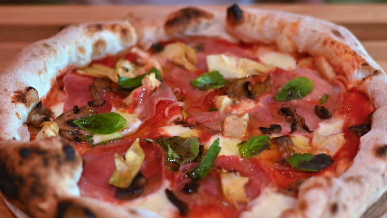 Pizza con funghi, prosciutto e carciofi, primo piano