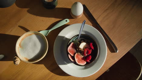 Breakfast-Brunch-on-Wooden-Table-with-yogurt,-fruits,-eggs-and-coffee