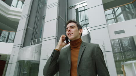 Hombre-De-Negocios-Caminando-En-El-Centro-De-La-Oficina-Y-Hablando-Por-Teléfono