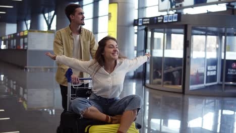 romantic couple in airport. attractive young woman and handsome man with suitcases are ready for traveling. having fun on