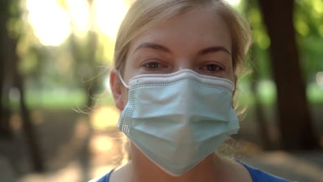 una mujer lleva una máscara médica en un parque 03