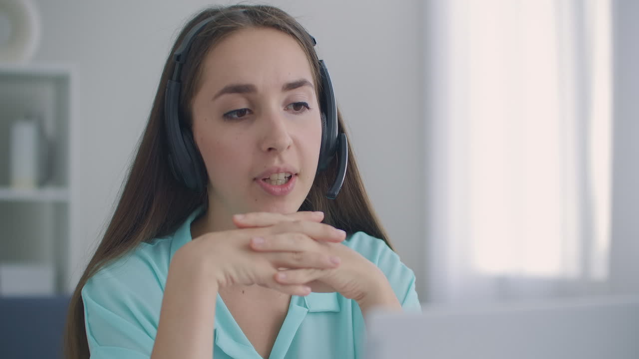 joven feliz mujer de negocios usa auriculares habla con cámara web haciendo llamada de videoconferencia en línea a distancia. maestra de internet haciendo chat a distancia trabajando desde casa. concepto de teletrabajo. vista de cámara web