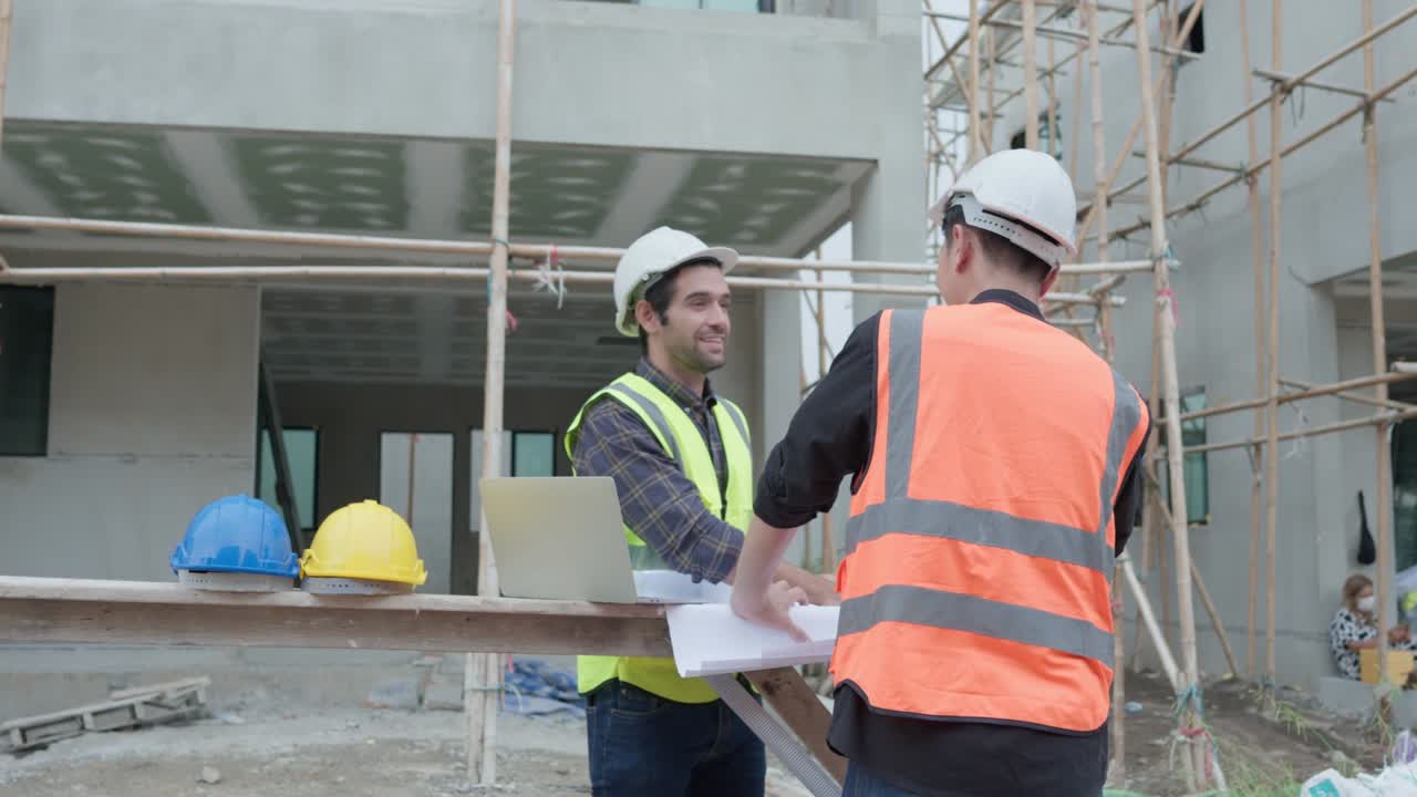 gerente profesional de ingenieros civiles masculinos o arquitectos y capataz, trabajador. mientras se reúnen discuten inspeccionar con computadora portátil, proyecto de construcción de planos en el sitio de construcción. concepto de construcción de bienes raíces.