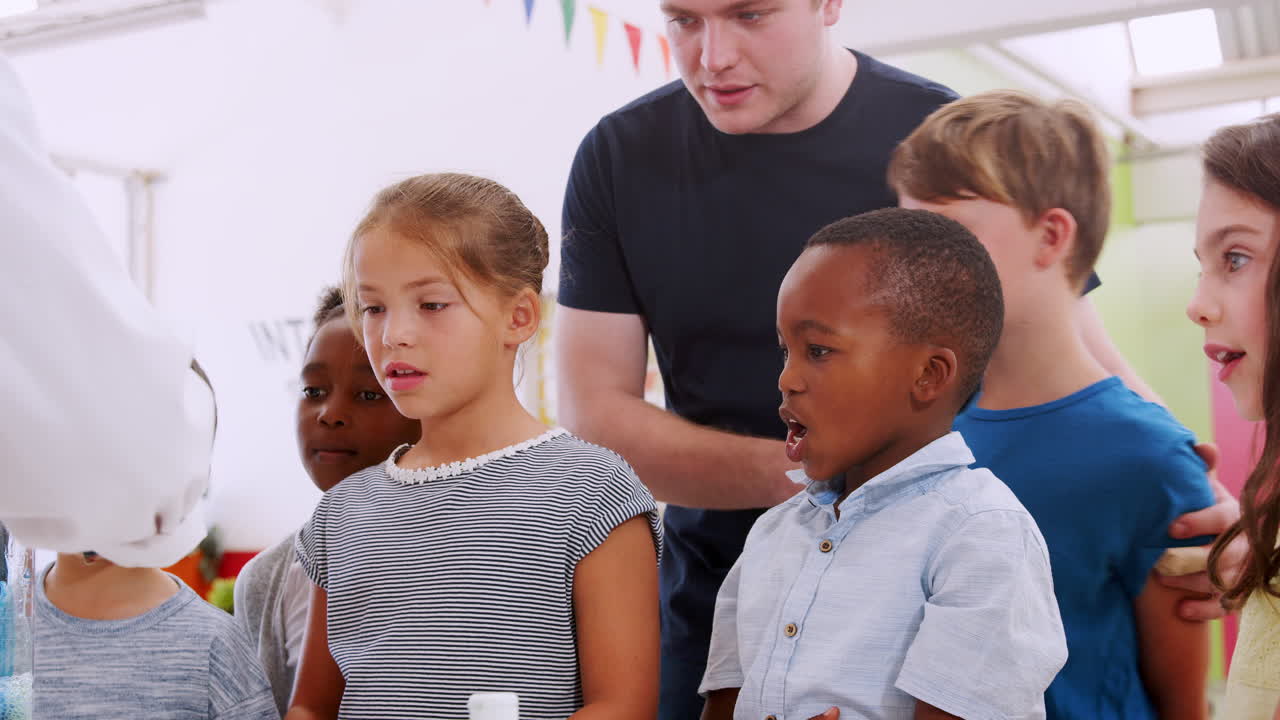 School kids and teacher watch experiment at a science centre