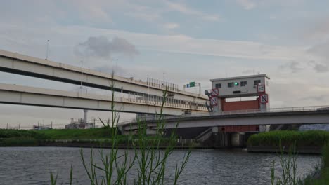 a wide shot of the sumida sluice gate with multiple layers of elevated highways and a bridge