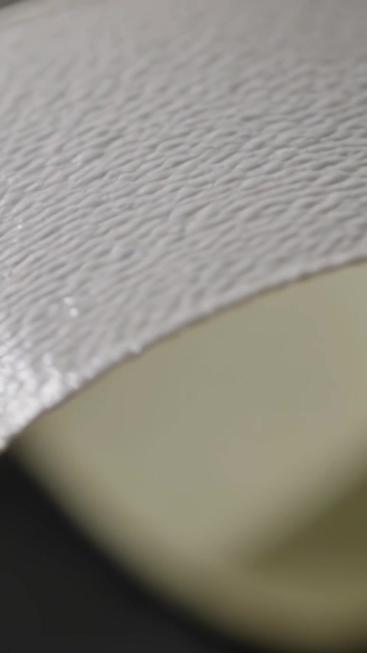 Vertical video: Panning camera revealing curved white surface inside room, exposing beige dark void