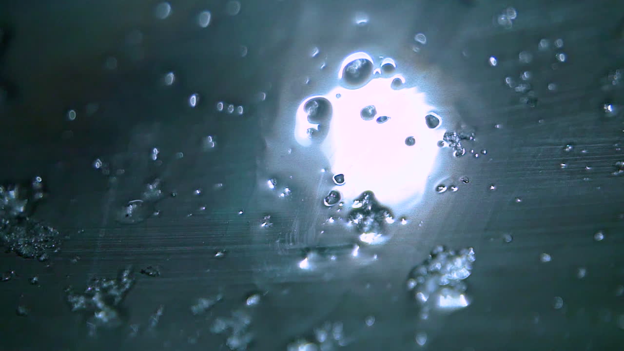 겨울 밤에 얼음 조각과 눈송이가 젖은 창문 아래로 미끄러집니다.