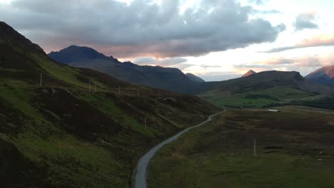 panning drone shot of scottish winding road with mountains